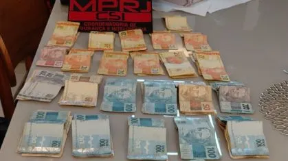 Celulares e quantia em dinheiro apreendidos durante a operação do GAECO/MPRJ que investiga policiais militares suspeitos de receber propina de traficantes na Baixada Fluminense. • Reprodução/MPRJ